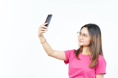 Beyaz arka planda izole edilmiş güzel Asyalı kadının akıllı telefonuyla bir selfie çek.