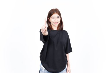 Beyaz arka planda izole edilmiş güzel bir Asyalı kadının tek bir parmağını gösteriyor.