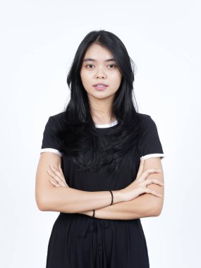 Kollarını kavuşturup gülümsüyor ve beyaz arka planda izole edilmiş güzel Asyalı kadının kamerasına bakıyor.