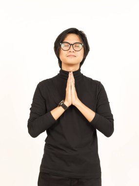 Katlanmış eller, kapalı gözler ve beyaz arka planda tecrit edilmiş yakışıklı Asyalı adamın duası.