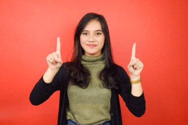 Gülümseyen kamera ve Kızıl Arkaplanda tecrit edilmiş güzel bir Asyalı kadını işaret ediyor.