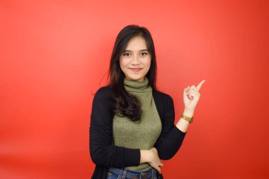 Kırmızı Arkaplanda Tecrit Edilen Güzel Asyalı Kadın Forefinger 'ı kullanarak Ürün ve İşaret Tarafı Gösteriliyor