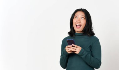 Akıllı telefon, beyaz arka planda izole edilmiş güzel Asyalı kadının mutlu yüzüne bakıyor.