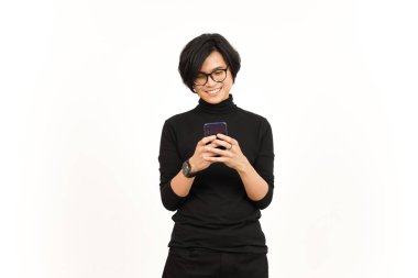 Beyaz arka planda yalnız bırakılmış yakışıklı Asyalı adamın gülümseyen yüzüyle akıllı telefonu tutmak ve kullanmak