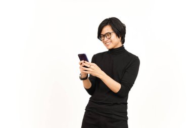 Beyaz arka planda yalnız bırakılmış yakışıklı Asyalı adamın gülümseyen yüzüyle akıllı telefonu tutmak ve kullanmak