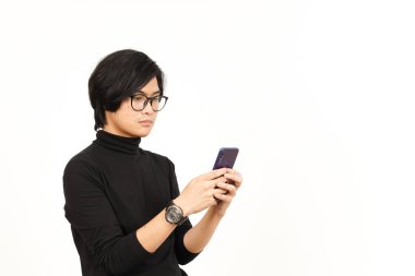 Beyaz arka planda izole edilmiş yakışıklı Asyalı adamın kızgın yüzüyle akıllı telefonu tutmak ve kullanmak