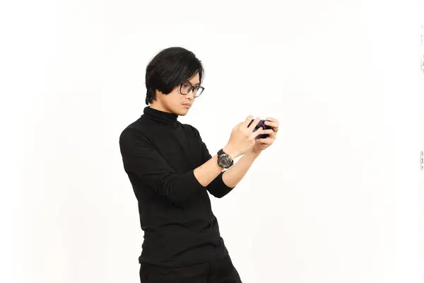 ホワイトバックグラウンドで孤立したハンサムアジア人のスマートフォンでモバイルゲームをプレイ — ストック写真