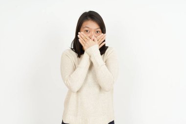 Beyaz arka planda izole edilmiş güzel Asyalı bir kadının elleriyle ağzını kapatıyor.