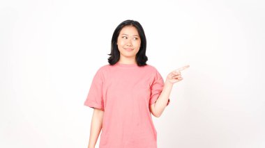 Beyaz arka planda izole edilmiş güzel Asyalı kadının gülümseyen ve işaret eden yan kopyası.