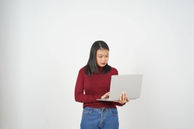 Dizüstü bilgisayarda çalışan genç Asyalı kadın beyaz arka planda kırmızı tişört giyiyor.