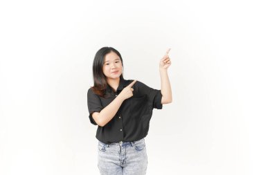 Beyaz arka planda siyah tişört ve kot pantolon giyen Asyalı genç bir kadın sunuyor ve işaret ediyor.