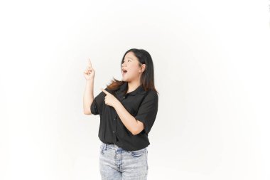Beyaz arka planda siyah tişört ve kot pantolon giyen Asyalı genç bir kadın sunuyor ve işaret ediyor.