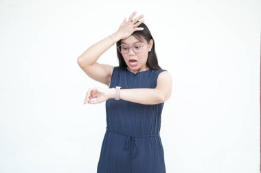 Güzel Asyalı kadın şokta saatine bakıyor, geç kaldığını fark ediyor, beyaz bir arka planda.