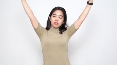 Güzel Asyalı kadın, beyaz arka planda yorgunluk belirtileri göstererek vücudunu esnetir.