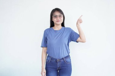 Güzel Asyalı kadın yan fotokopi alanına işaret ederken gülümsüyor, beyaz arka planda reklam veya promosyonlar için mükemmel.