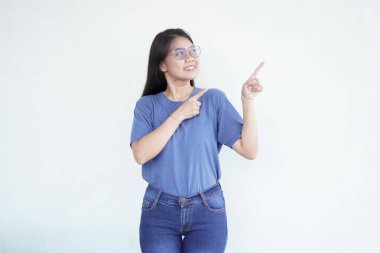 Güzel Asyalı kadın yan fotokopi alanına işaret ederken gülümsüyor, beyaz arka planda reklam veya promosyonlar için mükemmel.