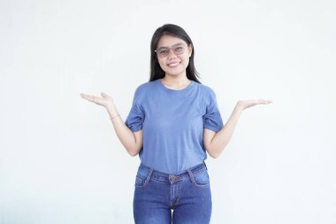 Güzel Asyalı kadın avuçlarında beyaz bir arka planda ürünü sergilerken sıcak bir şekilde gülümsüyor.