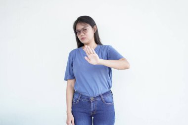 Güzel bir Asyalı kadın, beyaz bir arka plana karşı reddedilme jesti olarak avucunu ileri doğru tutar.
