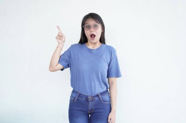 Güzel Asyalı kadın parmaklarıyla işaret ediyor, temiz beyaz bir arkaplanda.