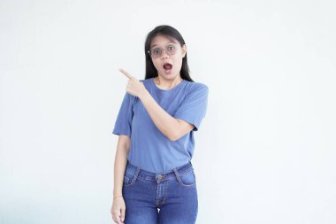 Güzel Asyalı kadın parmaklarıyla işaret ediyor, temiz beyaz bir arkaplanda.