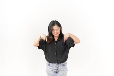 Güzel bir Asyalı kadın, beyaz bir arkaplanı işaret ederken ışıl ışıl gülümser.