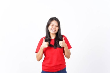 Kameraya bakıp gülümseyen ve güzel Asyalı kadının beyaz arka planda izole edilmiş kırmızı tişörtünü gösteren.