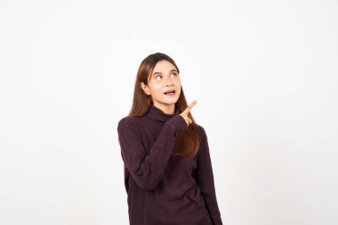 Gülümseyen ve işaret eden yan fotokopi alanı beyaz arka planda izole edilmiş güzel bir Asyalı kadının reklamını gösteriyor.