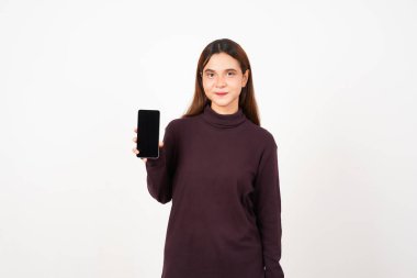 Beyaz arka planda izole edilmiş güzel Asyalı kadının boş ekranlı akıllı telefonunu sunarak ve tutarak gülümseme