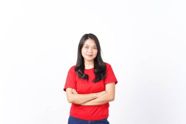 Kollarını kavuşturup gülümsüyor ve beyaz arka planda kırmızı giyen güzel Asyalı kadının kamerasına bakıyor.