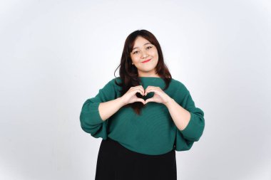 Kameraya gülümseyen ve aşk işareti gösteren, Beyaz Arkaplanda tecrit edilmiş Güzel Asyalı Kadın