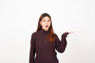 Beyaz arka planda izole edilmiş güzel Asyalı kadının şok olmuş yüzüyle açık avuçta boş bir alan göstererek ve sunarak