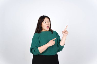 Beyaz arka planda yeşil giyinen güzel Asyalı Kadın 'ın Fotokopi Alanı' nda Ürün ve İşaret Tarafı gösteriliyor