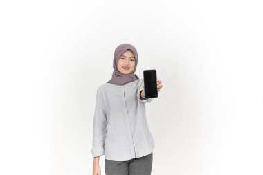 Beyaz Arkaplanda izole edilmiş tesettürlü Güzel Asyalı Kadın Uygulamaları için boş ekran akıllı telefonu sunan ve tutan gülümseyen