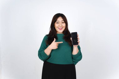 Elinde akıllı telefonuyla gülümseyen, beyaz arka planda izole edilmiş güzel Asyalı Kadın 'ın reklamları veya uygulamaları için boş ekranı gösteren ve gösteren.