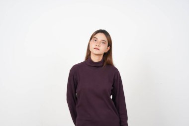 Beyaz arka planda izole edilmiş güzel Asyalı kadının ciddi doğal yüzüne bakıyorum.