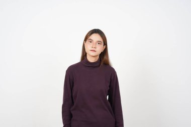 Beyaz arka planda izole edilmiş güzel Asyalı kadının ciddi doğal yüzüne bakıyorum.