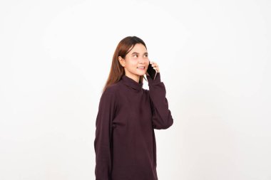 Elinde akıllı bir telefonla, beyaz arka planda izole edilmiş güzel bir Asyalı kadının telefonuna gülüyor.