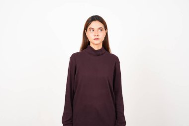 Beyaz arka planda tecrit edilmiş Asyalı güzel bir kadının ciddi yüzüyle yan tarafa bakıyor.