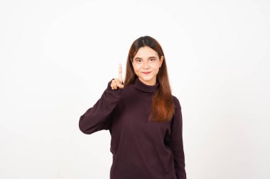 Gülümseyen ve parmaklarını gösteren güzel Asyalı kadının bir parmağı beyaz arka planda soyutlanmış.