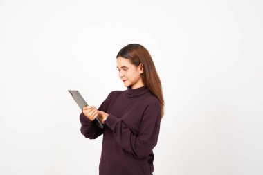 Gülümseyen ve beyaz arka planda izole edilmiş güzel bir Asyalı kadının tabletini kullanan