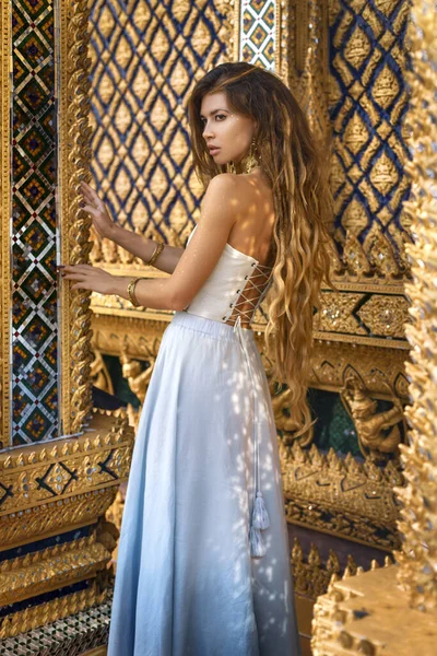 beautiful young woman in elegant dress at asian temple