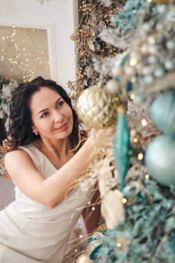 Kız Noel ağacını süslüyor. Dikey resim.