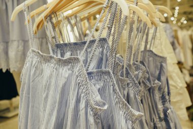 Mağazadaki askıda yazlık elbiseler. Seçici odaklanmayı kapat.