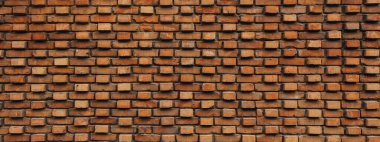 Özel duvarlı kırmızı tuğla duvar. Duvardan tuğlalar sarkıyor. Pankart biçimi, geniş.