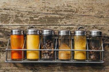 Ahşap bir arka planda baharatlı kavanozlar ve metin için yer..