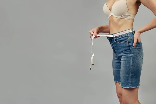 Emagrecimento Menina Com Fita Métrica Jeans Fragmento Close Estúdio Filmado — Fotografia de Stock
