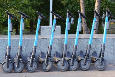 Arka arkaya birkaç mavi kiralık scooter..