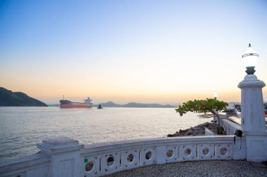 Tanker öğleden sonra Santos limanına geliyor. Şehrin ünlü duvarları ve lambaları ön planda..