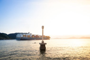 Santos limanından ayrılan konteynırlarla dolu bir gemi şehrin simgesinin önünde..