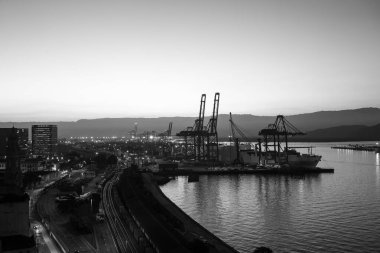 Santos şehir merkezinin bir kısmının ve akşam limanın havadan görüntüsü. Arka planda, Serra do Mar dağları.